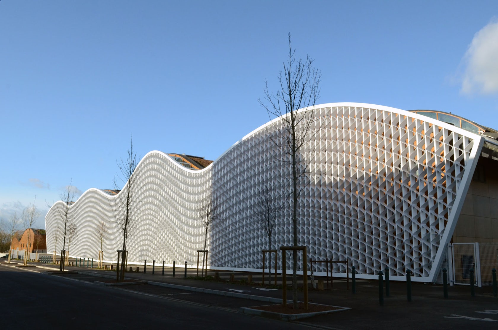 Верхние плавные. Центр водных видов спорта Mantes-la-Jolie Франция. Современные здания. Волнообразный фасад. Фасады круглых зданий.